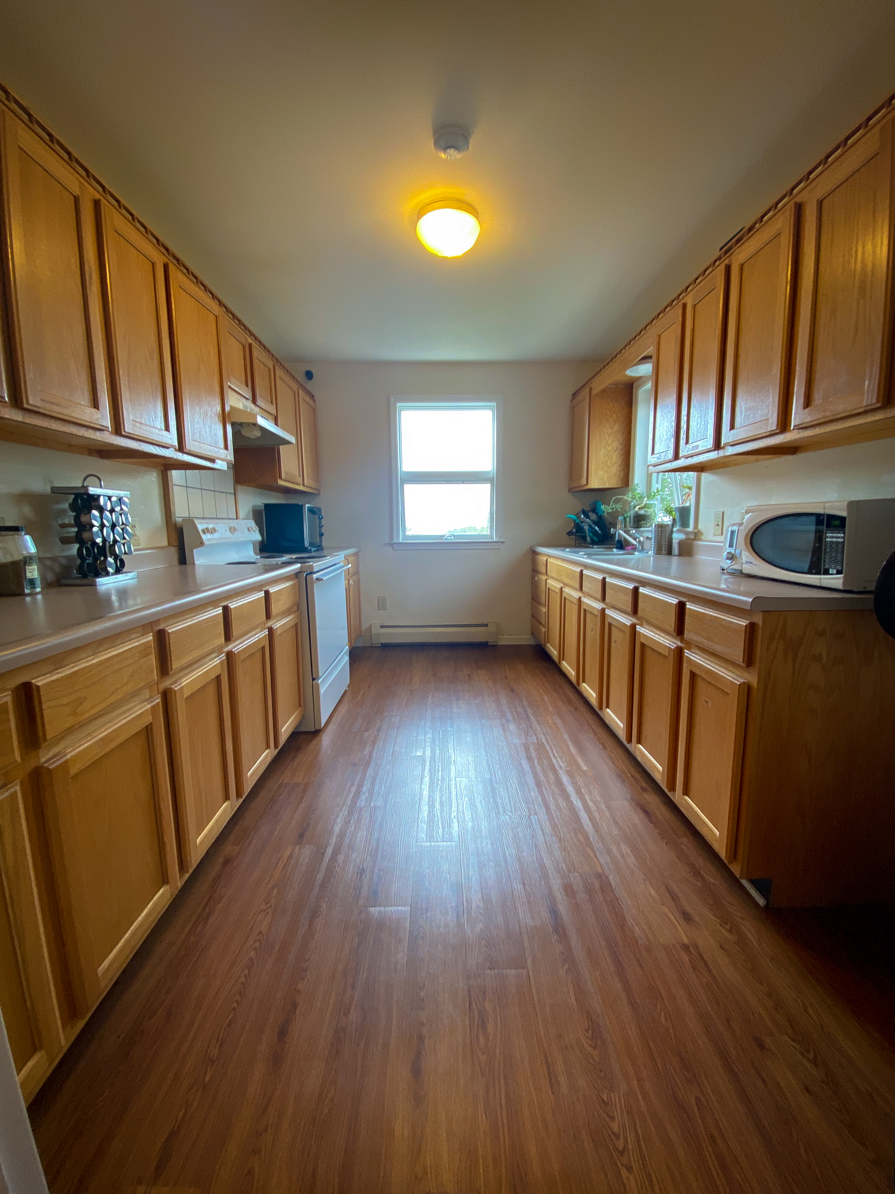 Extended galley kitchen with bright window light